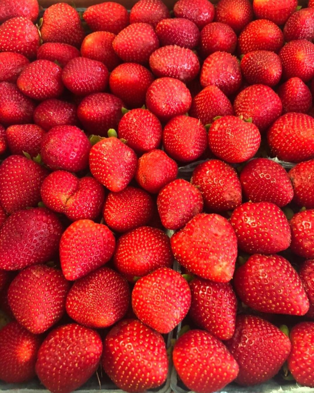 Fresh, ripe strawberries piled together, showcasing their vibrant red color and distinct texture, ideal for desserts, salads, and healthy snacks.